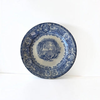 Her Good Eye vintage ceramic dinner plate with blue and white pastoral landscape transferware and ornate scrollwork.