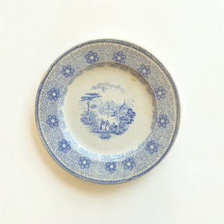 Her Good Eye vintage ceramic dinner plate with blue and white pastoral landscape transferware and floral border.