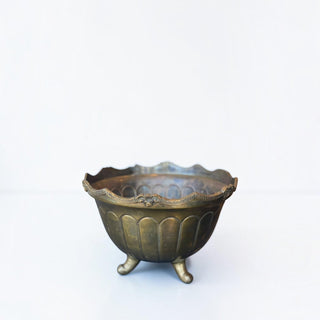Her Good Eye vintage brass footed bowl with ornate scalloped rim and aged patina on a white background.