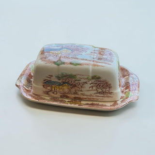 Her Good Eye vintage ceramic butter dish with scenic landscape design and floral border tray. Earthy tones.