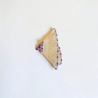 Her Good Eye vintage cream crochet doily with intricate open-weave pattern and variegated purple scalloped edge.