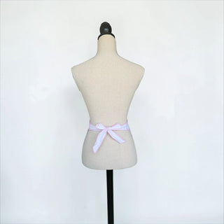 Her Good Eye vintage style white half apron with pink striped ties tied in a bow on a mannequin back view