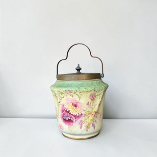 Her Good Eye vintage ceramic biscuit jar in pale green and cream with hand-painted floral motifs and brass handle.