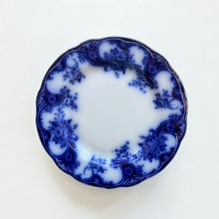 Her Good Eye vintage porcelain dinner plate with cobalt blue floral patterns and a scalloped, embossed rim.