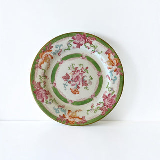 Her Good Eye vintage porcelain dinner plate with hand-painted pink, orange, and green floral motifs on white.