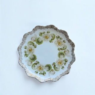 Her Good Eye vintage ceramic plate with scalloped gold-tone edge and water lily floral motif on white background