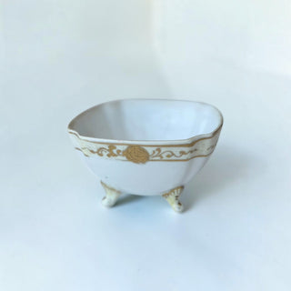 Her Good Eye vintage white porcelain footed bowl with gold filigree and floral accents on a scalloped rim.