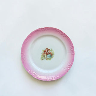 Her Good Eye vintage porcelain plate with pink scalloped rim, embossed scrollwork, and hand-painted Victorian couple.
