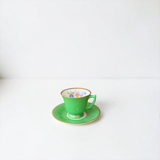 Her Good Eye vintage porcelain tea cup and saucer in green with gold trim and hand-painted floral interior motif.