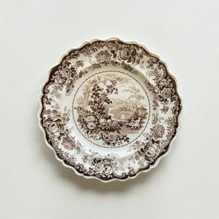 Her Good Eye vintage ceramic dinner plate with sepia pastoral landscape, floral border, and elegant scalloped edge.