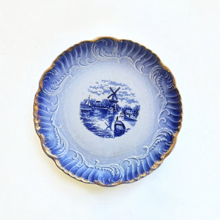 Her Good Eye vintage ceramic plate featuring a blue and white Dutch windmill landscape with gold-gilded scalloped edges