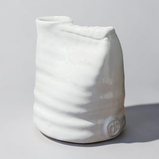Her Good Eye white ceramic vase with unique crumpled bag shape and wave-like indentations. Glossy finish.