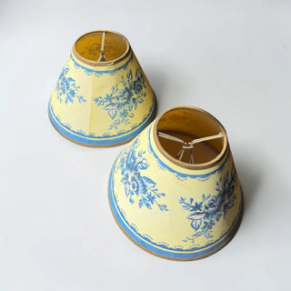 Her Good Eye set of 2 yellow bell-shaped lampshades with blue floral pattern and trim. Fabric construction.
